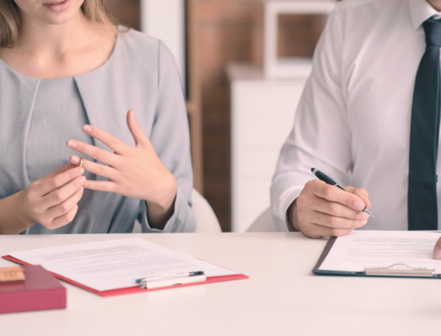 Einvernehmliche Scheidung – Begleitung mit Empathie und Expertise Frau beim Gespräch mit Anwalt über einvernehmliche Scheidung und Ringabnahme